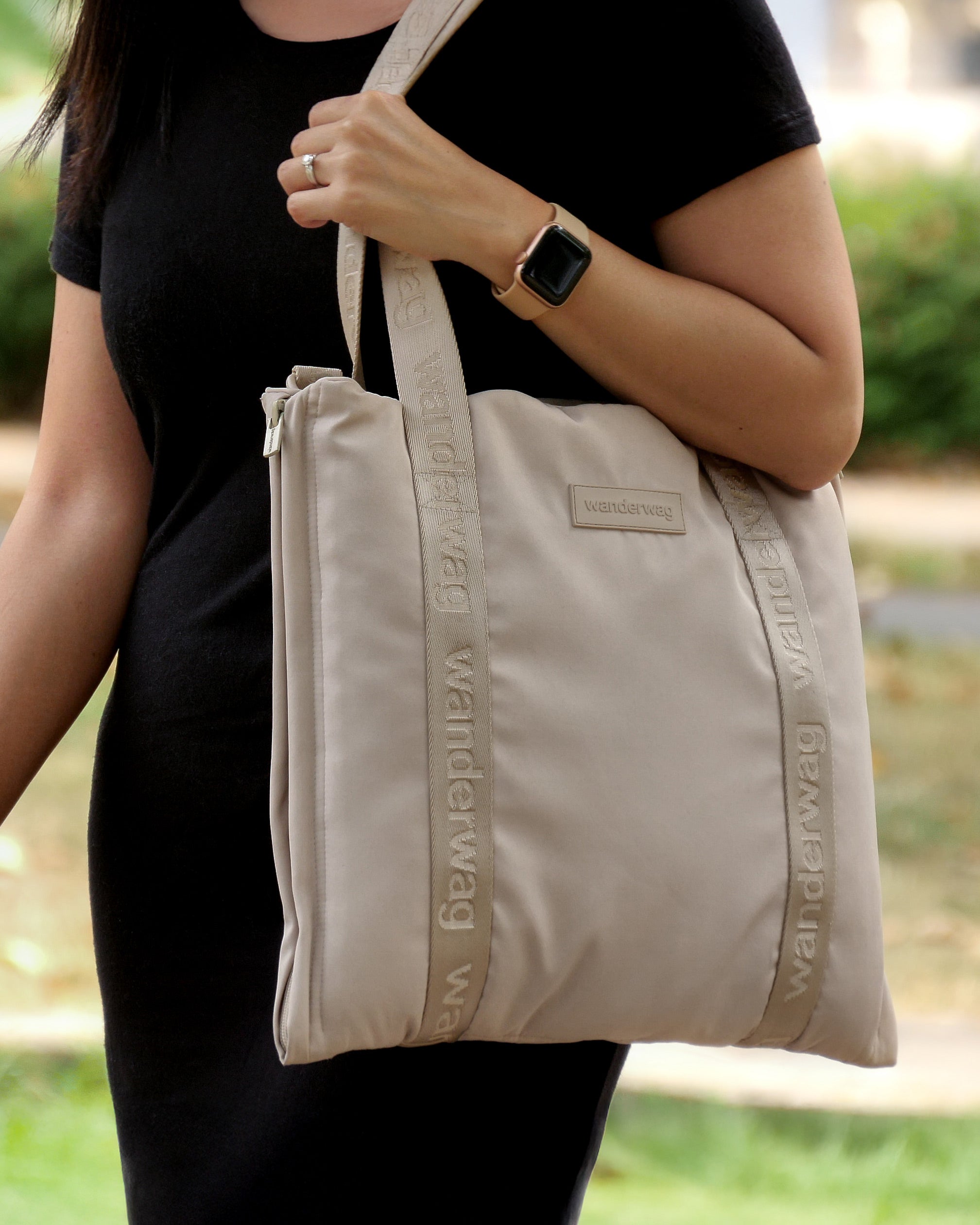 women with tote hanging off her shoulder as she walks