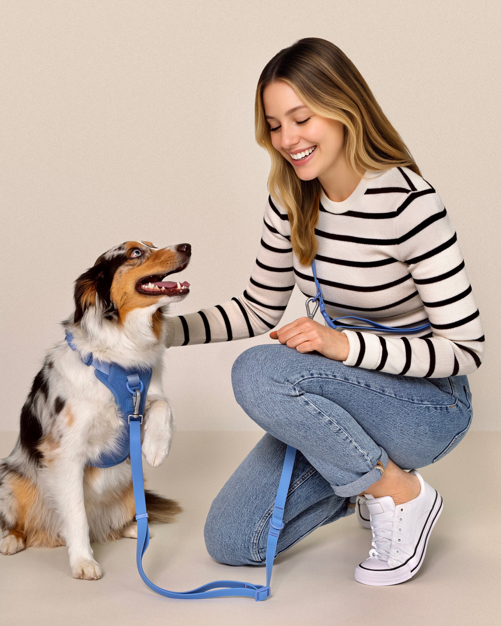 dog wearing harness with a female human sitting next to the dog