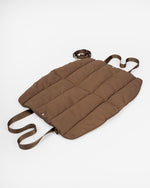 dog bed laying on a white studio backdrop