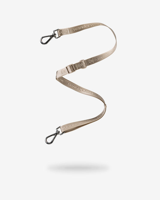 the leash that can be used as a cross body strap for the tote is being displayed on a white back drop